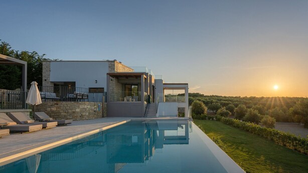 A modern house with a swimming pool, outdoor seating, and a view of the sunset. - Skyline Villa II, By Hellocrete (Aggeliana)
