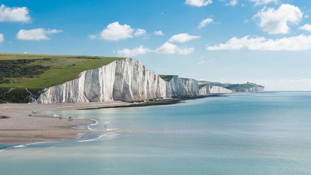 A coastal landscape with white cliffs, a sandy beach, and calm sea. - Cleve Cottage by inspirestays.com - a cottage that sleeps 4 guests in 2 bedrooms (Lewes)