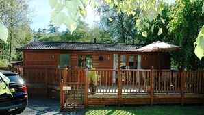 Une cabane en bois avec un porche et un patio couvert.