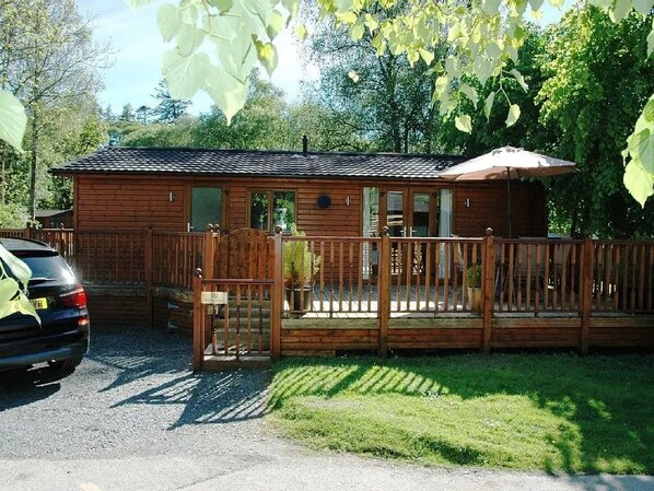 En stuga av trä med en veranda och en täckt uteplats.
