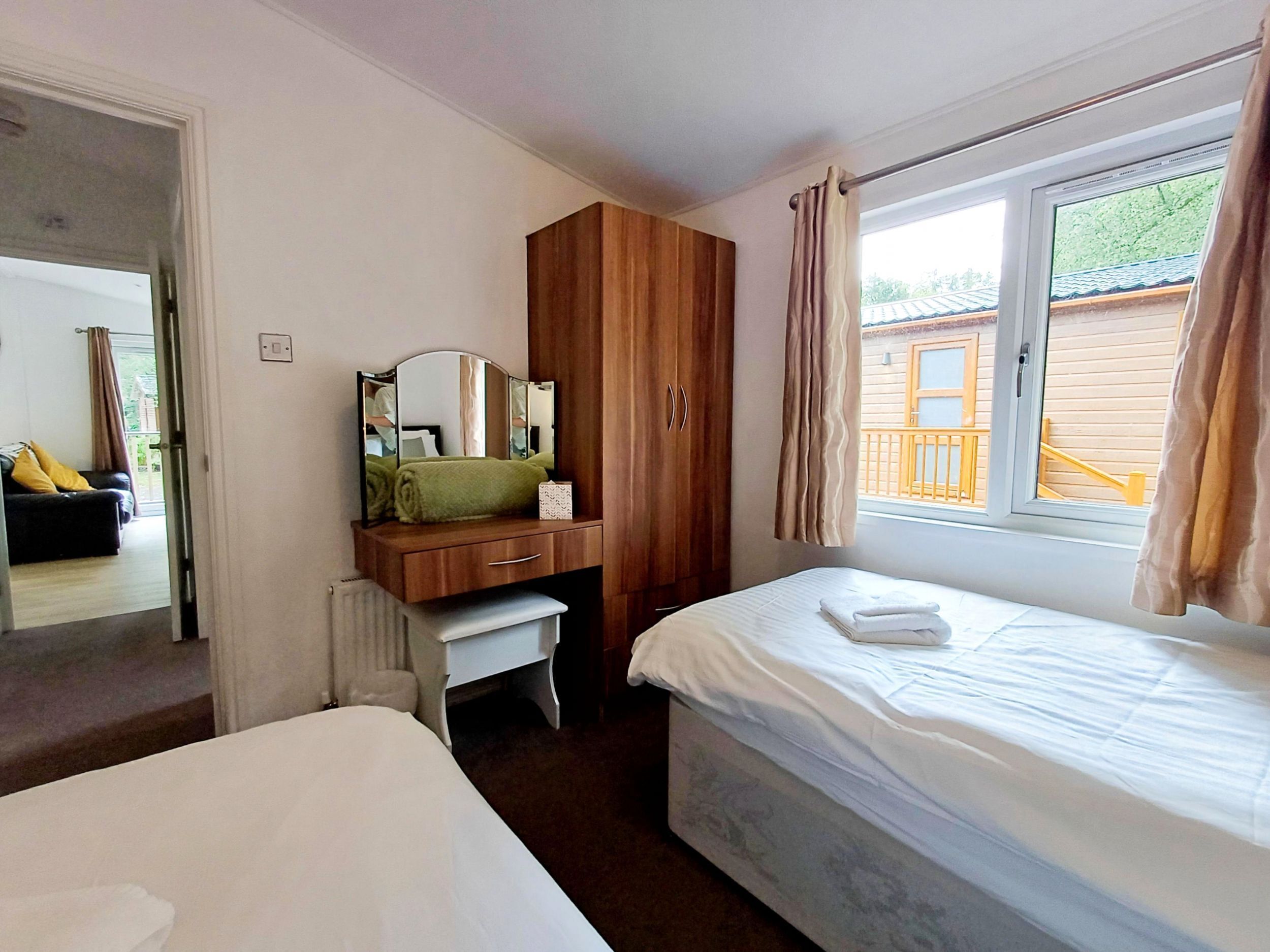 Une chambre à coucher avec un lit, un bureau doté d’un miroir et une armoire.