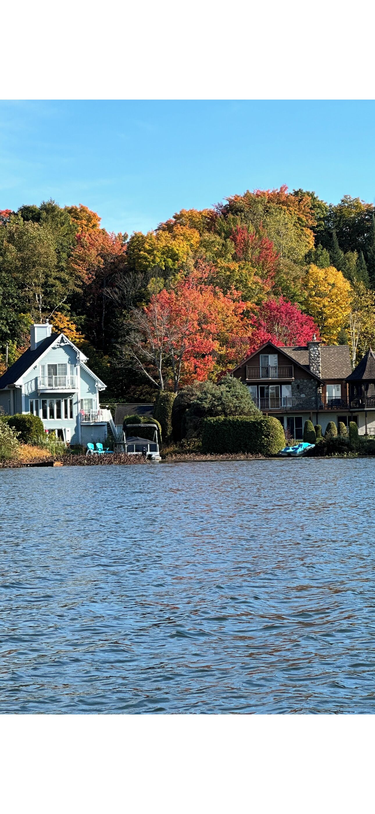 Une maison au bord du lac, avec un quai et un bateau.