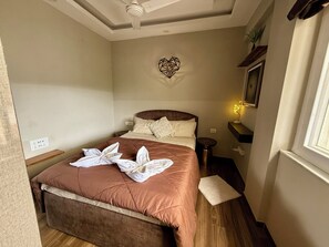 Una habitación de hotel con una cama, una mesita de noche, una lámpara y un adorno en la pared.
