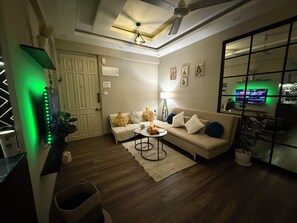 Una sala de estar con sofá, mesa de centro y televisor.