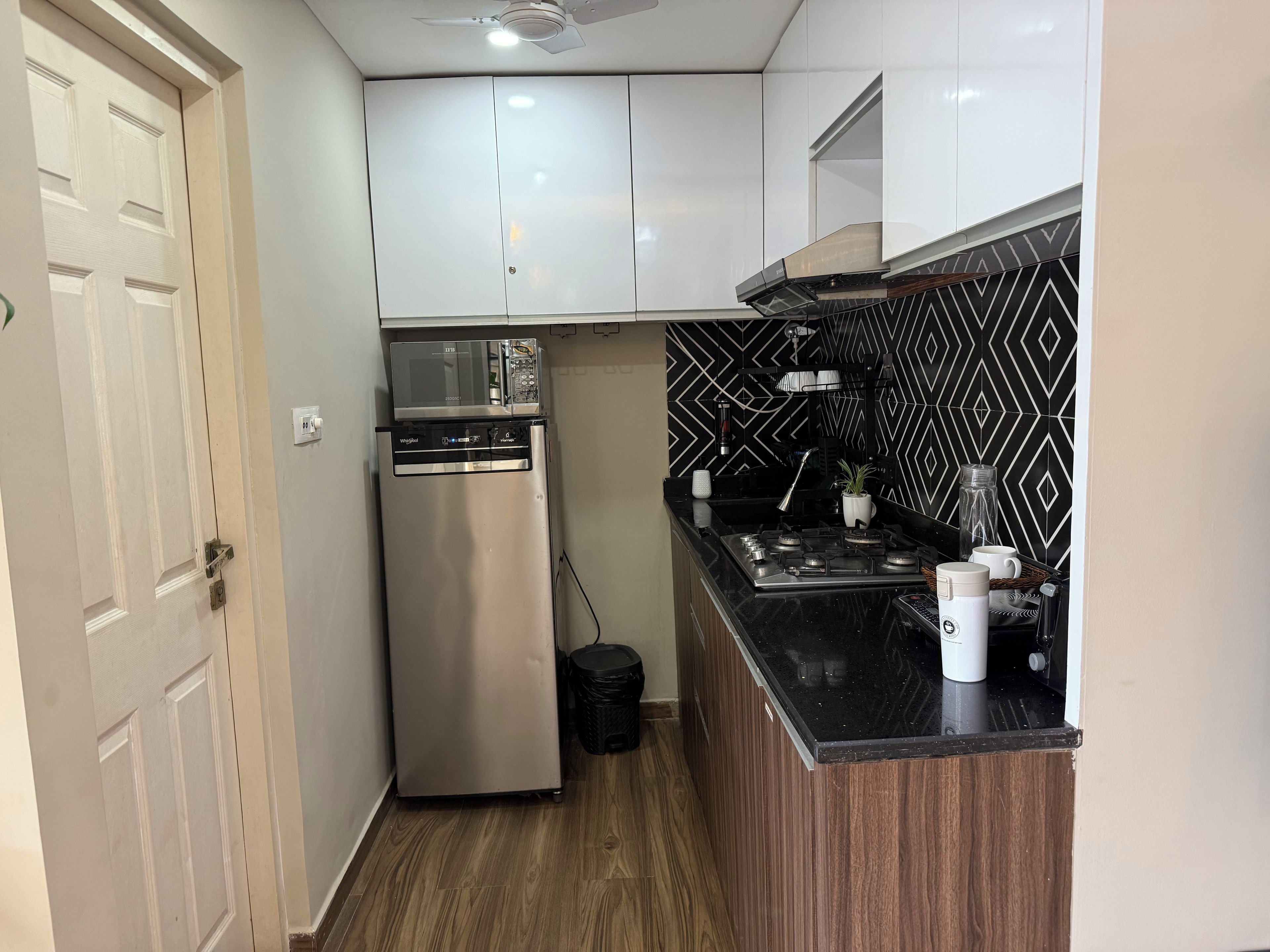 A compact kitchen with a built-in microwave, dishwasher, and gas stove.