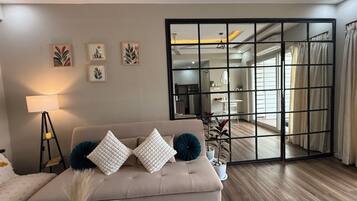 A modern living room with a sofa, a lamp, and artwork on the wall.