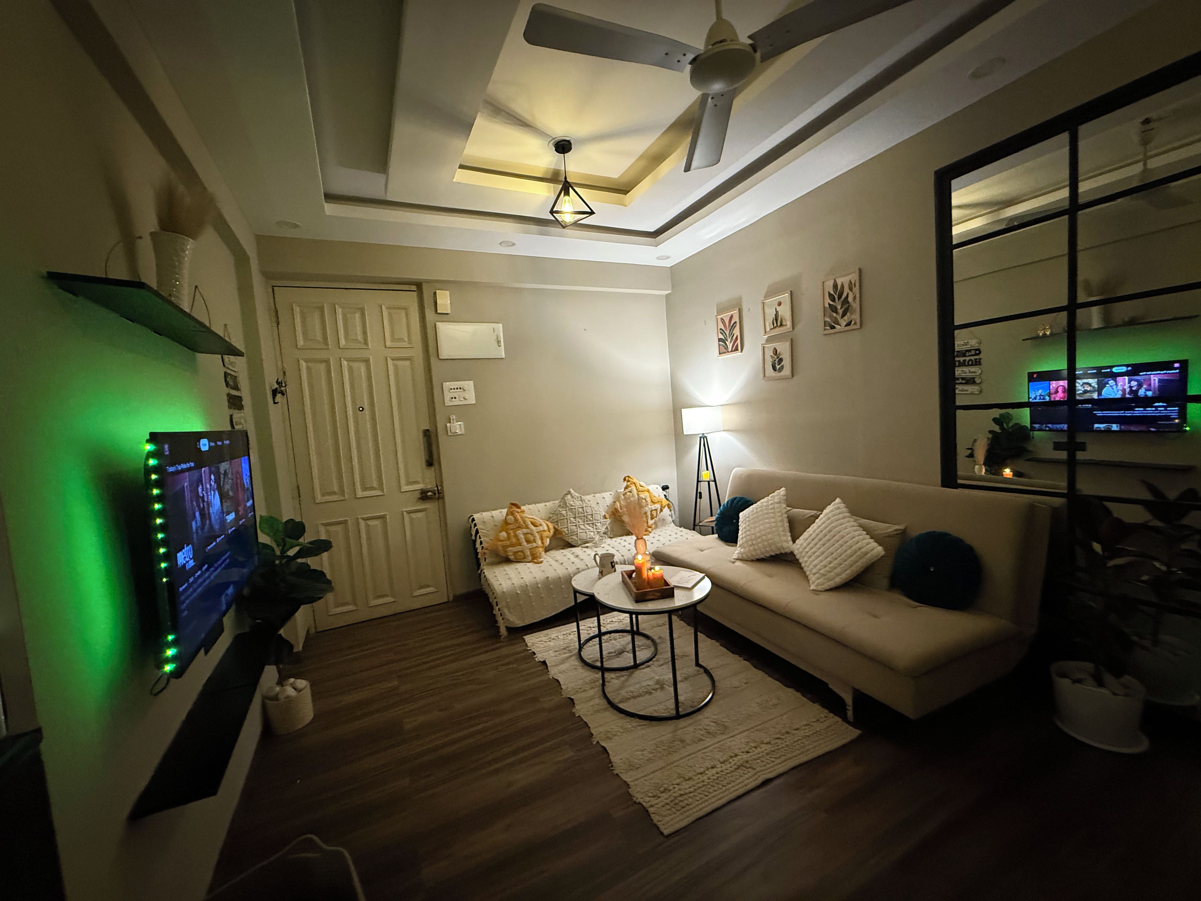 Un soggiorno con divano, tavolino, televisore e ventilatore a soffitto.