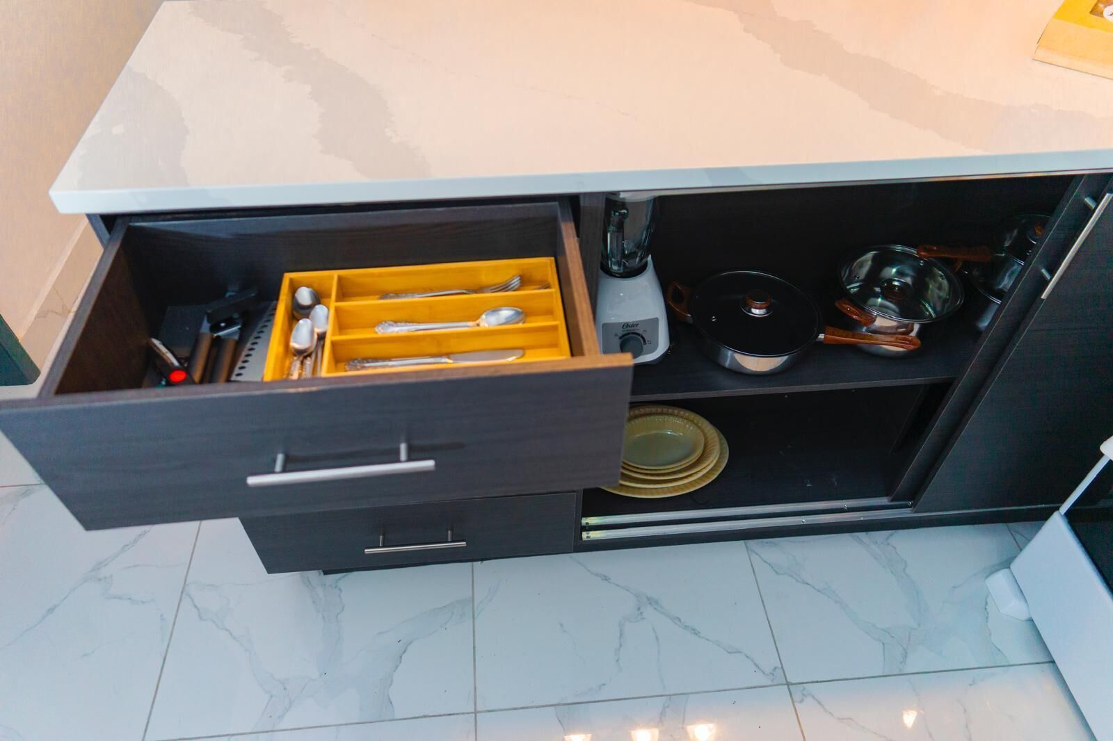 A kitchen drawer with utensils and cookware.