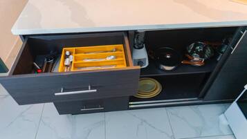 A kitchen drawer with utensils and cookware.