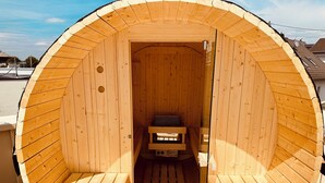 A wooden sauna with a bench and a bench seat inside.