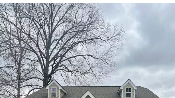 Une maison à deux étages avec une entrée à l’avant, un garage et une pelouse bien entretenue.