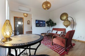 Apartment, Garden View | Living area | 50-inch Smart TV with digital channels