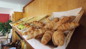 A breakfast buffet with croissants, apples, and juice bottles. - Quinta do Canal (Odemira)