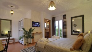 A hotel room with a bed, a TV, a bathroom, and a large mirror. - Quinta do Canal (Odemira)