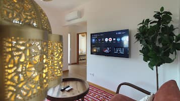 Apartment, Garden View | Living area | 50-inch Smart TV with digital channels