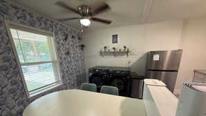 Cocina compacta con comedor, lavadora y refrigerador.
