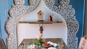 A dining table set with various dishes, a decorative wall, and a hanging lantern. - Petra Masterpiece  (Wadi Musa)