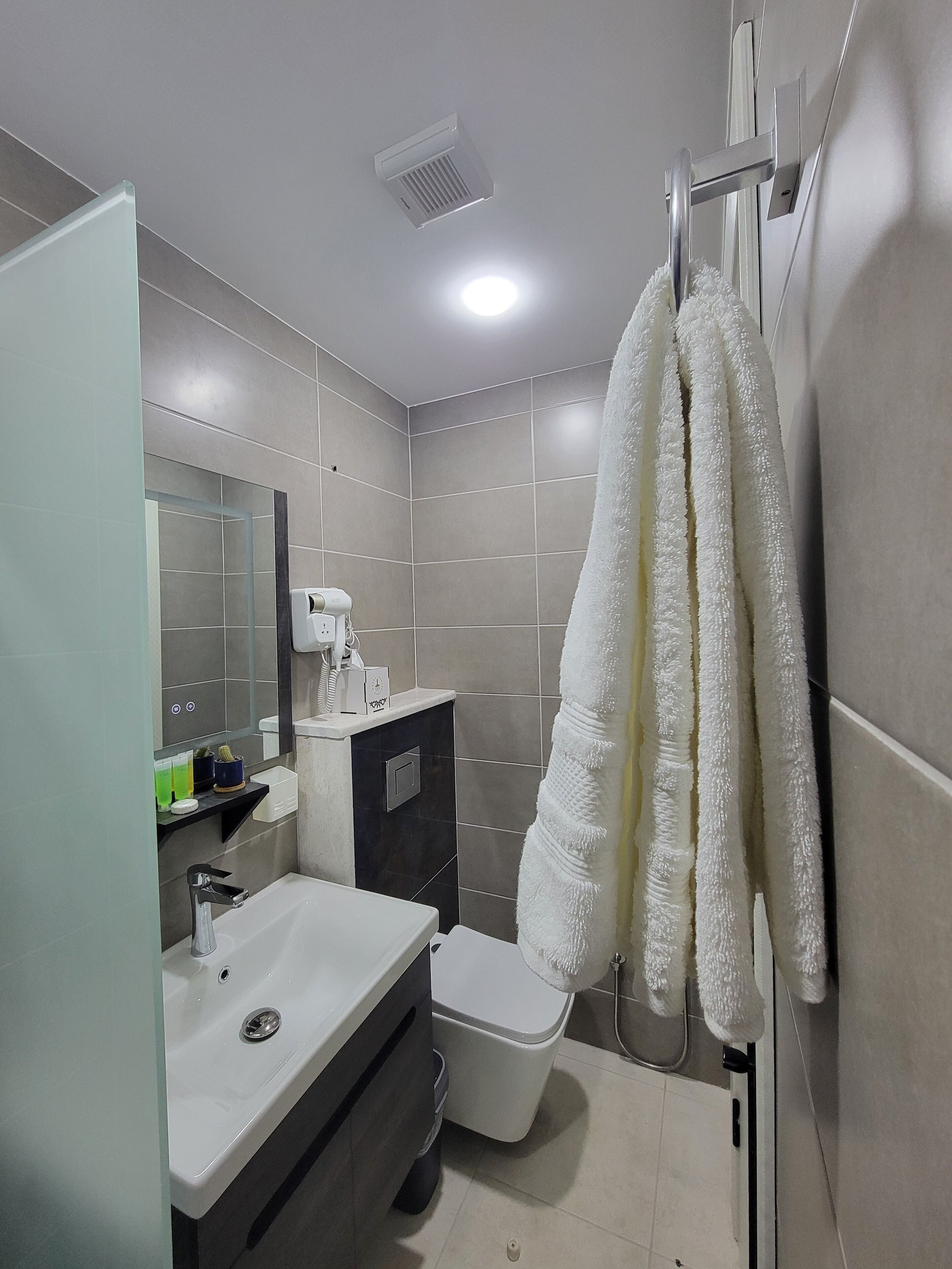 Ein modernes Badezimmer mit Waschbecken, Toilette und Handtuchhalter.
