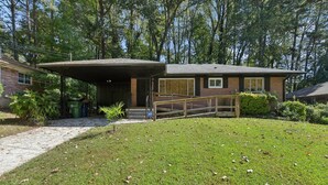 A single-story brick house with a covered porch and a small front yard.