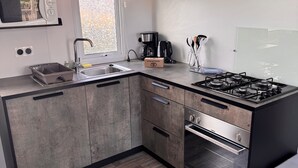 Une cuisine moderne équipée d’un four à micro-ondes, d’un évier, d’une machine à café et d’une cuisinière à gaz.