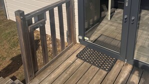 Une maison moderne dotée d’une porte-fenêtre coulissante, d’une petite fenêtre et d’une terrasse en bois.