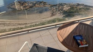 Een balkon met uitzicht op een rotsachtige kustlijn en de zee.