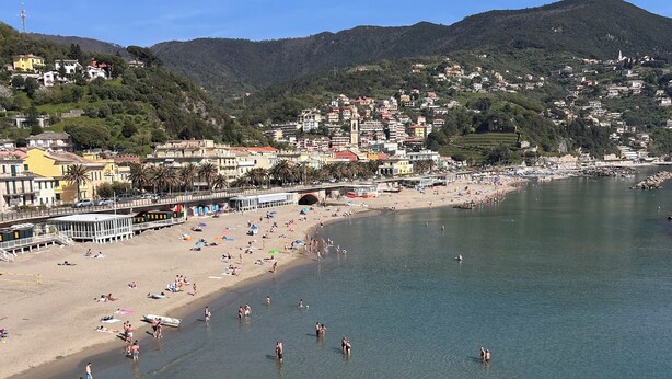A coastal town with a beach, clear waters, and a backdrop of hills. - B&B La Volpe (Moneglia)