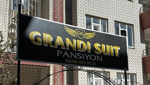 A building with a sign for "GRANDI SUIT PANSIYON" and a contact number. - Grandi Suit Pansiyon (Elazığ)