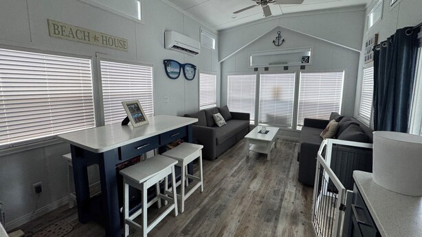 A beach-themed living room with a sofa, a coffee table, and a small bar area. - Delightful Tiny home with amazing views in Key Largo (Key Largo)