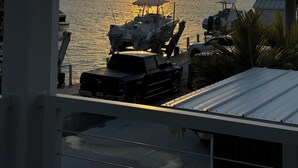 A sunset view from a dock with boats and a building in the foreground. - Delightful Tiny home with amazing views in Key Largo (Key Largo)