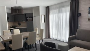 A modern hotel room with a dining area, a sofa, and a kitchen. - 80m from resort center, 3rd floor, swimming pool, terrace, tv, ski locker, 57m², Gourette (Eaux-Bonnes)