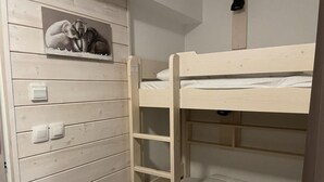 A bunk bed with a ladder, a shelf with a sculpture, and a light switch on the wall. - 150m from ski slopes, 3rd floor, view mountain, swimming pool, terrace, tv, ski locker, 28m² (Eaux-Bonnes)