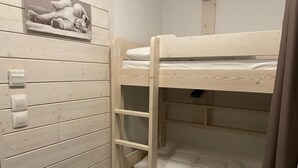 Una cama litera con escalera, un panel de pared de madera y un interruptor de luz.