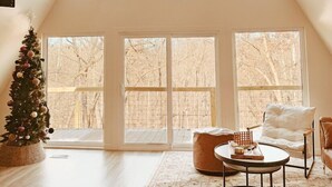 Un loft spacieux avec de hauts plafonds, de grandes fenêtres, un sapin de Noël et un coin salon confortable.