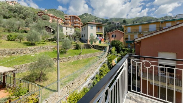 A hillside residential area with buildings, a grassy field, and a stone wall. - Rapallo Vintage House (Rapallo)