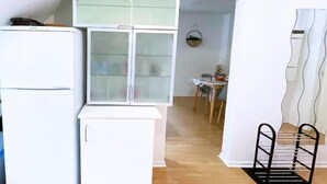 A compact kitchen with a refrigerator, a glass-fronted cabinet, and a dining area with a table and chairs. - Whole apartment 6p: apartment in residence - Campan, France (Campan)