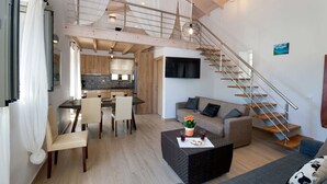 Un vaste espace de vie comprenant un escalier, un coin repas et une cuisine.