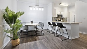Una cucina moderna con mobili bianchi, un piano di lavoro in granito e un forno a microonde integrato.
