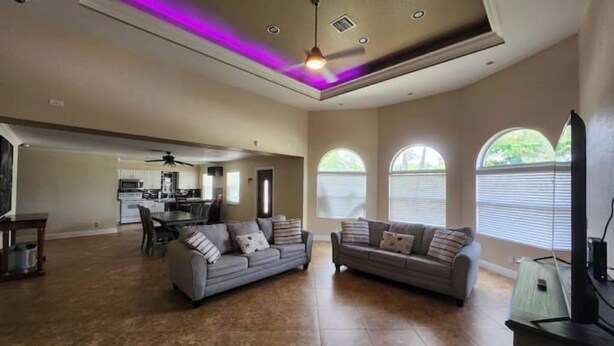 A spacious living room with two sofas, a dining area, and a kitchen in the background. - Margate Zen Paradise Water View (Margate)
