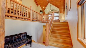 Una escalera de madera con barandal de madera que lleva a un nivel superior.