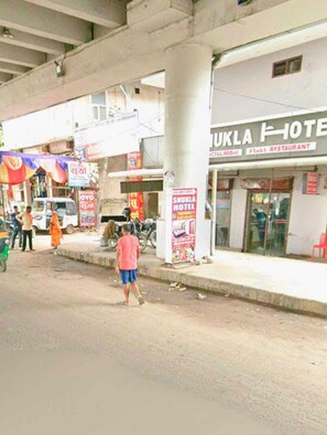 Un hôtel avec une enseigne publicitaire indiquant « Hôtel Shukla » et « Restaurant Shukla ».