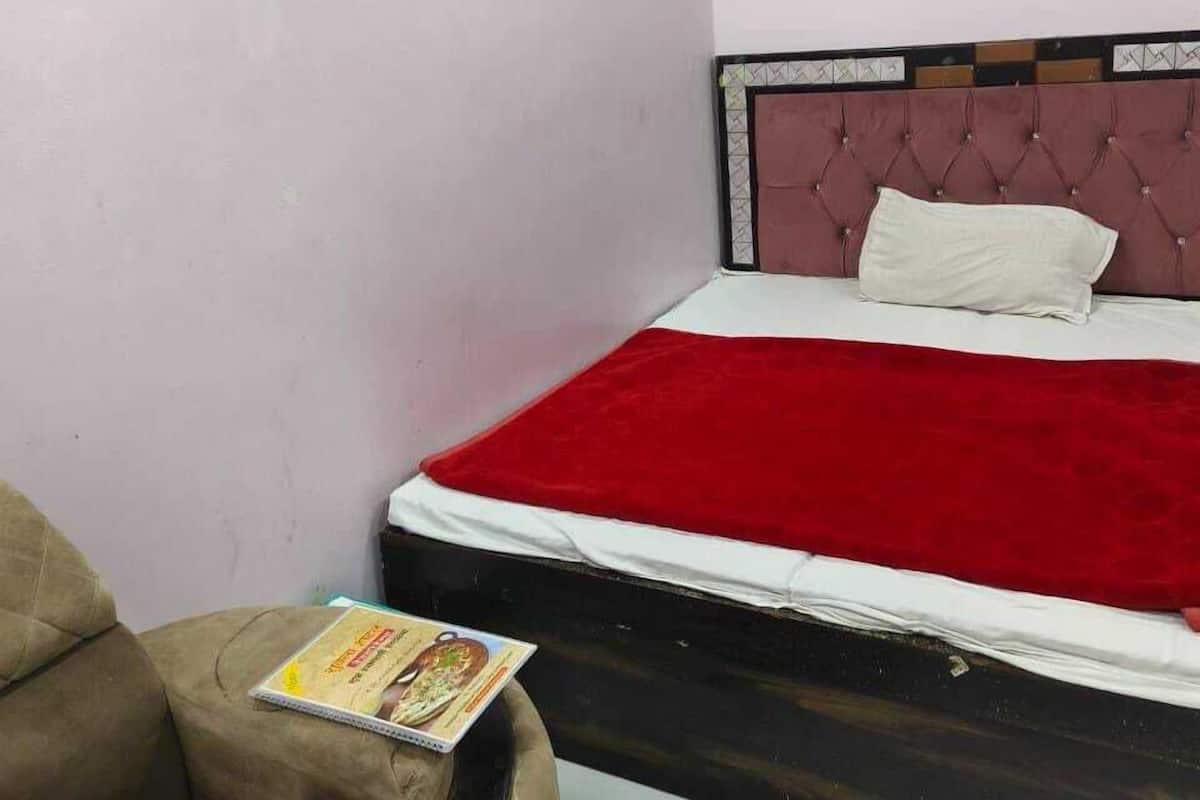 Um quarto com uma cama, uma cadeira e uma mesinha.