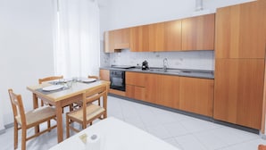 A modern kitchen with wooden cabinets, a built-in oven, and a sink.