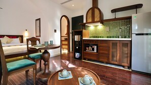 Ein Hotelzimmer mit Bett, Sitzgruppe, Küchenzeile und Esstisch.
