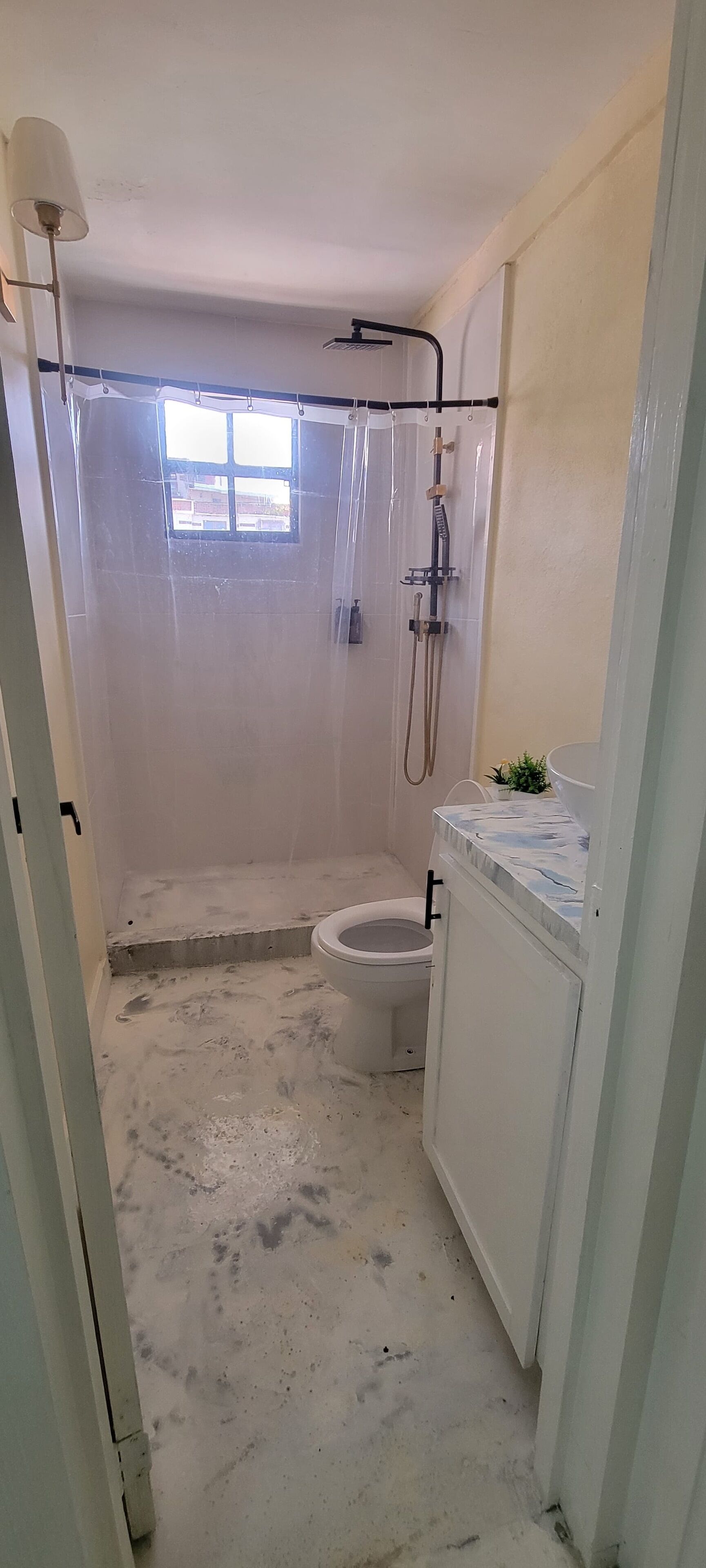 A bathroom with a shower, toilet, and a sink.