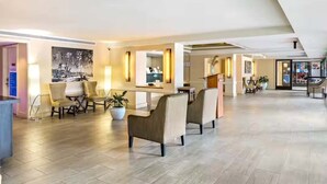 A spacious lobby with a reception desk, seating area, and a large potted plant. - Waikiki Ocean View Studio, 3 Beds, Block to Beach (Honolulu)