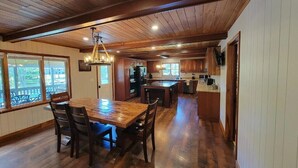 A spacious kitchen with wooden cabinets, a large island, and a dining area with a wooden table and chairs.