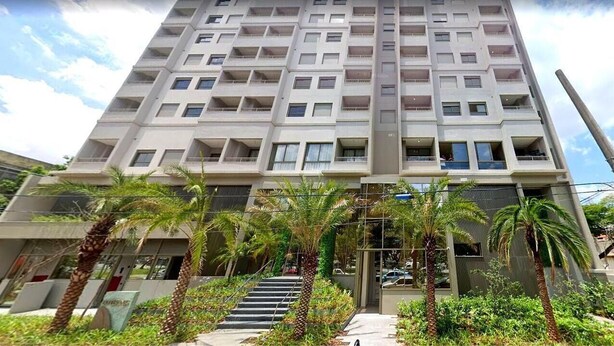 A multi-story building with balconies, a central staircase, and surrounding greenery. - Bothanic Campo Belo by Wecare Hosting (São Paulo)