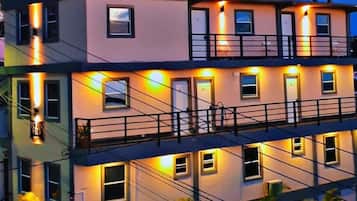 A multi-story building with balconies and exterior lighting.