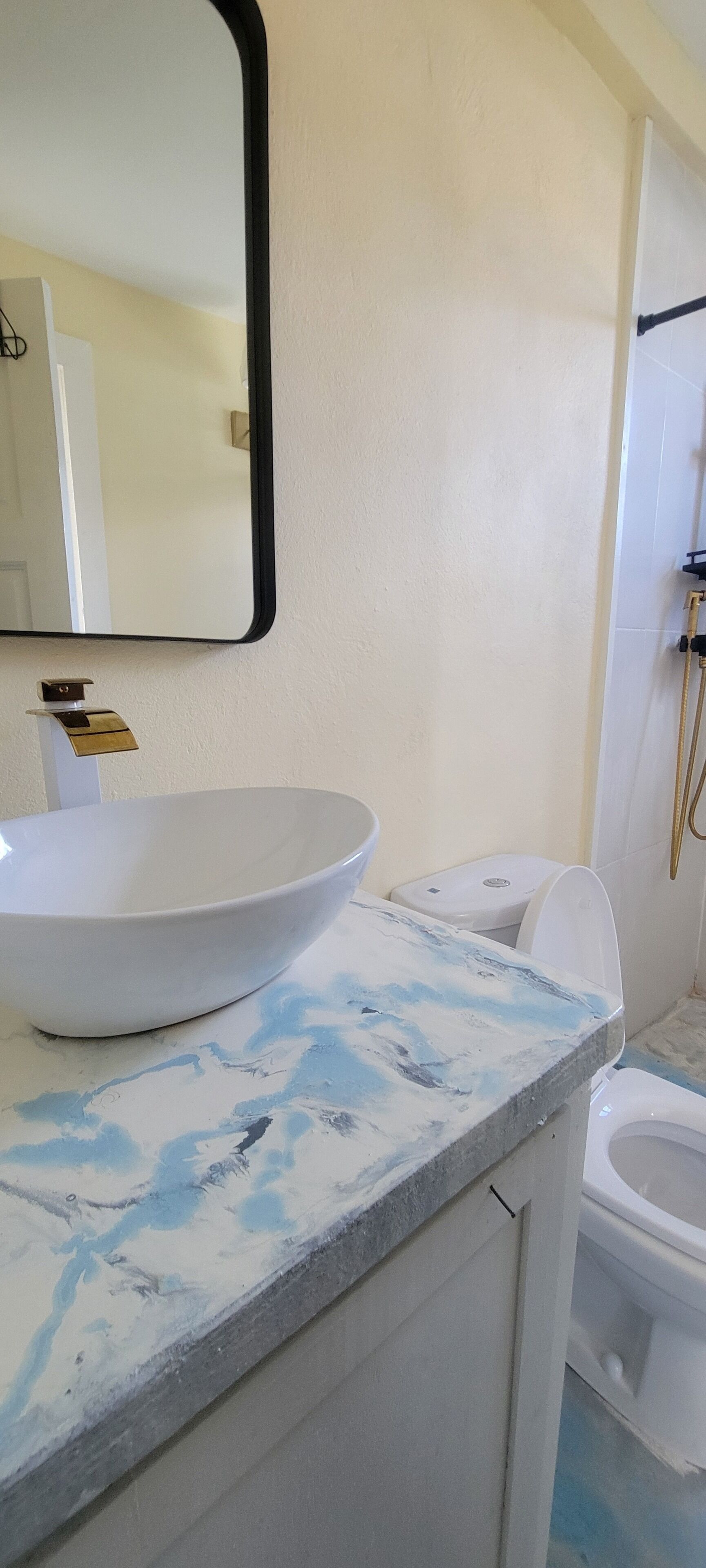 Un baño con lavamanos blanco, un espejo y un inodoro.